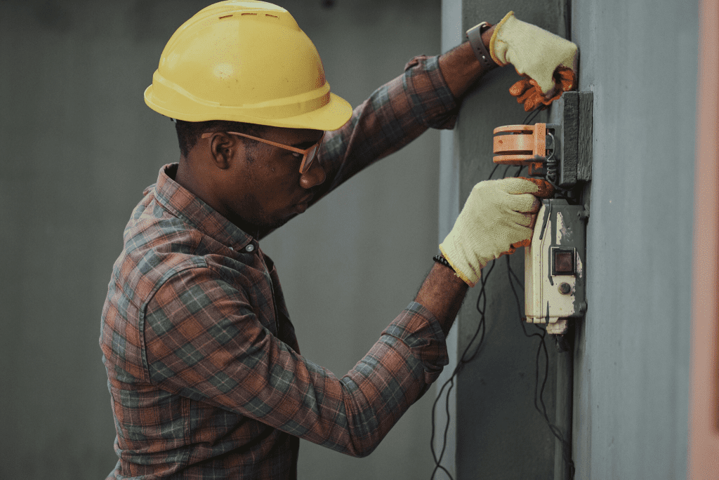 Contractor in a yellow helmet using tools