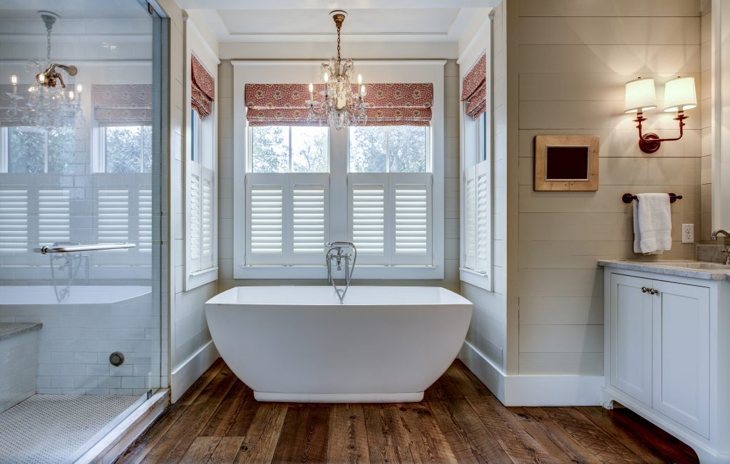 High end bathroom with large white bathtub, a chandelier are expected to be be home renovation trends for Toronto in 2022