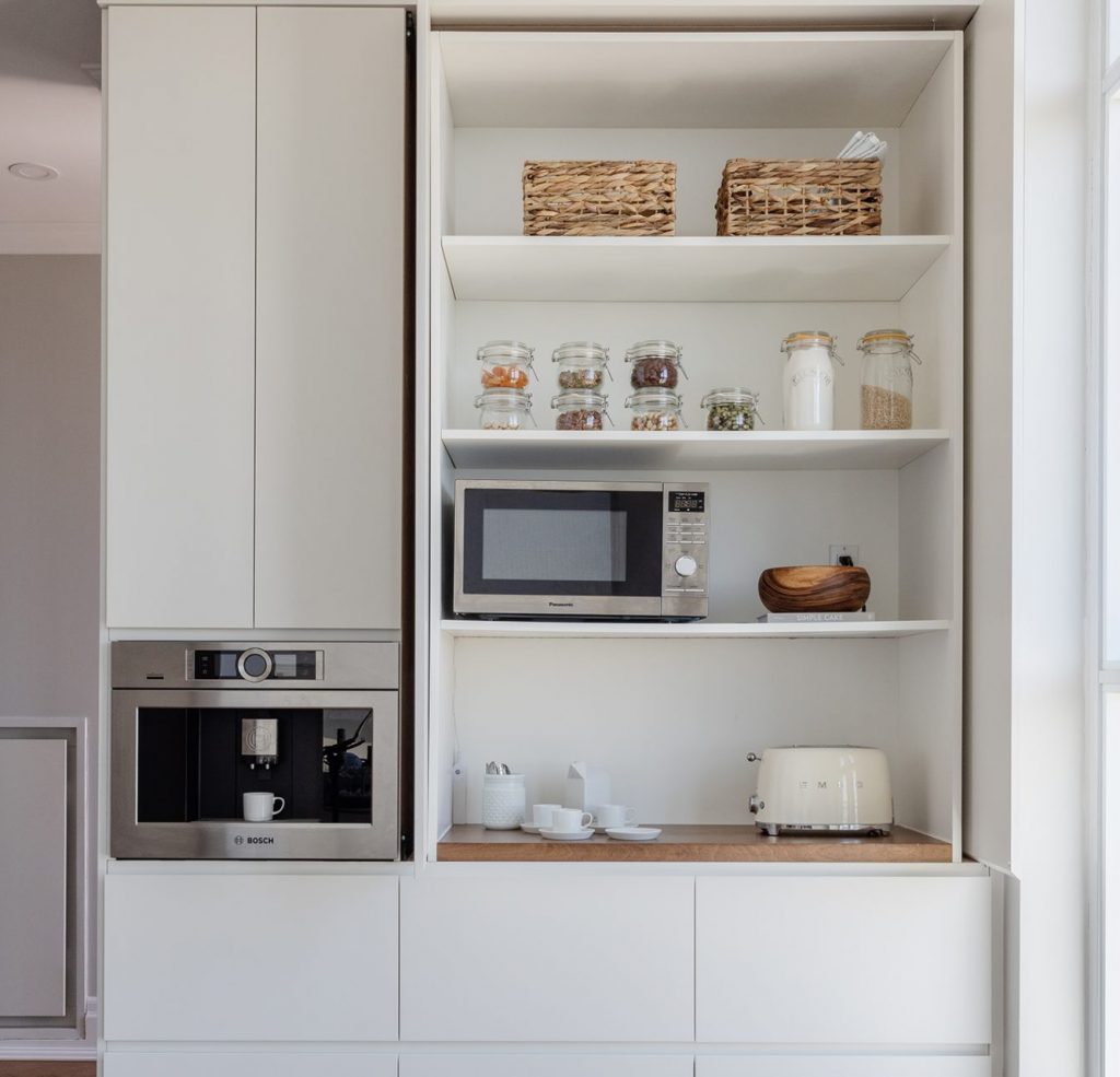 Appliance Garage in a modern kitchen with a microwave, a toaster and cutlery.